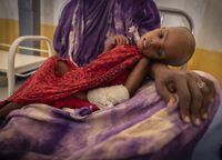 Hanu Ibrahim (38), holds her daughter Anisu Ebow in Trocare Satiation Center in Dolow, December 11, 2022.