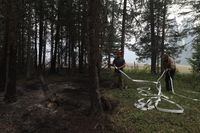 Neighbours help put out spots fires in forestry behind the Allgaier property in Neskonlith, B.C., on Aug. 20, 2023. (Aaron Hemens/The Globe and Mail)