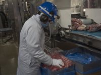 A worker packs meat at the Maple Leaf Foods plant in Brandon, Man.