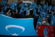 FILE - A protester from the Uyghur community living in Turkey, holds an anti-China placard during a protest in Istanbul, Thursday, March 25, against against the visit of China's FM Wang Yi to Turkey. The United States and several Western allies have presented a proposal for the U.N.’s main human rights body to hold a special debate over reported rights abuses and violations against Uyghurs and other Muslim minorities in China’s western Xinjiang region. (AP Photo/Emrah Gurel, File)