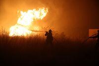 A firefighter tries to extinguish a wildfire burning near the village of Makri on the region of Evros, Greece, August 22, 2023. REUTERS/Alexandros Avramidis