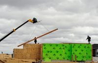 FILE PHOTO: Construction workers are seen alongside a crane as they build homes in Calgary, Alberta, May 31, 2010.    REUTERS/Todd Korol/File Photo