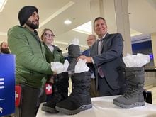 Manitoba Finance Minister Cliff Cullen gives two pairs of winter boots to members of the Downtown Community Safety Partnership in Winnipeg, Monday, March 6, 2023. Cullen made the donation a day before he was scheduled to deliver the provincial budget. THE CANADIAN PRESS/Steve Lambert
