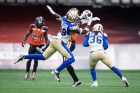 Winnipeg Blue Bombers' Donald Rutledge Jr. (38) intercepts a pas intended for B.C. Lions' Jevon Cottoy, back, during the second half of CFL football game in Vancouver, on Saturday, July 9, 2022. THE CANADIAN PRESS/Darryl Dyck