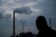 FILE PHOTO: A man walks past a coal-fired power plant in Shanghai, China, October 14, 2021. REUTERS/Aly Song/File Photo