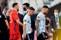 Argentina's Nicolas Otamendi, right, Argentina's Giovani Lo Celso, center, and Argentina's goalkeeper Emiliano Martinez walk off the field as the game against Brazil is interrupted by health authorities during a qualifying soccer match for the FIFA World Cup Qatar 2022 at Neo Quimica Arena stadium in Sao Paulo, Brazil, Sunday, Sept.5, 2021. Argentina walked off the field Sunday after only seven minutes of its World Cup qualifier against host Brazil after health officials came onto the pitch following coronavirus concerns about three Argentina players. (AP Photo/Andre Penner)