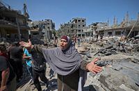 A Palestinian woman gestures as residents of Beit Hanun, in the northern Gaza Strip, assess the damage from Israeli air strikes on May 14.
