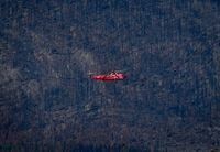 A helicopter being used to battle hot spots near Sorrento lands in Squilax, B.C., Wednesday, Sept. 6, 2023, as trees burned by the Bush Creek East wildfire are seen on a mountainside. The onset of large, severe wildfires that threaten communities year after year has occurred earlier in British Columbia than previous research projected, and experts say the record-shattering 2023 season must serve as a springboard for action. THE CANADIAN PRESS/Darryl Dyck