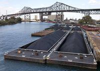 Petcoke is stored on barges on the Calumet River near the Chicago Skyway Bridge in Chicago. Chicago Mayor Rahm Emanuel has ordered the city Health Department to adopt regulations for petcoke, while aldermen introduced competing ordinances to regulate or ban it outright.