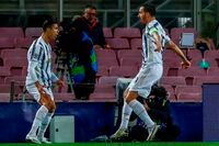 Juventus' Cristiano Ronaldo, left, celebrates after scoring his side's first goal during the Champions League group G soccer match between FC Barcelona and Juventus at the Camp Nou stadium in Barcelona, Spain on Dec. 8, 2020.