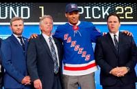 FILE - In this June 22, 2018, file photo, K'Andre Miller, second from right, wears a New York Rangers jersey and cap after being selected by the team during the NHL hockey draft in Dallas.