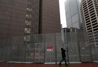 A person walks past a temporary security fence outside Hennepin County Government Center, in Minneapolis, Minn., on March 10, 2021.