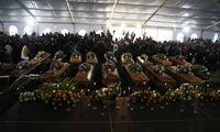 A view of the coffins during a funeral service held in Scenery Park, East London, South Africa, Wednesday, July 6, 2022. More than a thousand grieving family and community members are attending the funeral in South Africa's East London for 21 teenagers who died in a mysterious tragedy at a nightclub nearly two weeks ago. South African President Cyril Ramaphosa is due to give the eulogy for the young who died. (AP Photo)
