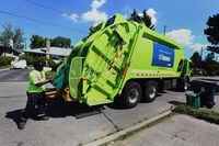 An employee of GFL waste collection picks up recycling and compost in the neighbourhood of Sheppard Avenue and Dufferin Street in Toronto.