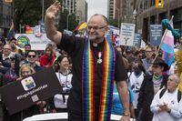 Rev. Brent Hawkes, the pastor who officiated Canada's first legally recognized same-sex marriages, rides a in car during Toronto's Pride Parade on Sunday, June 28, 2015. Russia has today sanctioned a raft of Canadian public figures including Major-General Michael Wright, Head of Canadian Forces Intelligence command, and the well-known Toronto pastor. THE CANADIAN PRESS/Chris Young
