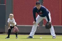 Atlanta Braves' Freddie Freeman stands with his child, Charlie Freeman, during a workout ahead of the NLCS playoff baseball game, Thursday, Oct. 14, 2021, in Atlanta. (AP Photo/Brynn Anderson)