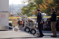 Law enforcement personnel operate a bomb disposal robot outside a post office which had been evacuated in Wilmington, Delaware, U.S. October 25, 2018.  REUTERS/Mark Makela