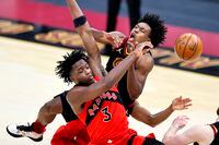 Cleveland Cavaliers' Collin Sexton (2) and Toronto Raptors' OG Anunoby (3) battle for a loose ball in the second half of an NBA basketball game, Sunday, March 21, 2021, in Cleveland. The Cavaliers defeated the Raptors 116-105.