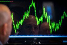 A trader watches his chart while working on the floor of the New York Stock Exchange July 8, 2014.