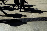 Businessmen cast their shadows as they walk in Toronto's financial district on Monday, Feb. 27, 2012. A new study shows Canadian employers are willing to hire workers without experience related to the job due to a tight labour market. THE CANADIAN PRESS/Nathan Denette