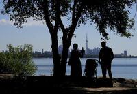 A family take pictures in the shade on a hot day in Toronto on Thursday, June 23, 2022. THE CANADIAN PRESS/Nathan Denette