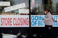 A man passes a closed store in Niles, Ill., on May 21, 2020.