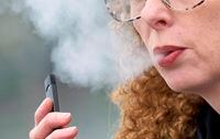 FILE - In this April 16, 2019 file photo, a woman exhales while vaping from a Juul pen e-cigarette in Vancouver, Wash. Schools have been wrestling with how to balance discipline with treatment in their response to the soaring numbers of vaping students. Using e-cigarettes, often called vaping, has now overtaken smoking traditional cigarettes in popularity among students, says the Centers for Disease Control and Prevention. Last year, one in five U.S. high school students reported vaping the previous month, according to a CDC survey. (AP Photo/Craig Mitchelldyer)