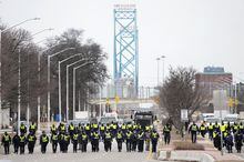 Police walk the line to remove truckers and supporters after a court injunction gave police the power to enforce the law after protesters blocked the access leading from the Ambassador Bridge in Windsor, Ont., Sunday, Feb. 13, 2022. The federal government is giving Windsor up to $6.9 million in compensation for dealing with "Freedom Convoy" protests that blocked the Ambassador Bridge in the southwest Ontario city earlier this year. THE CANADIAN PRESS/Nathan Denette