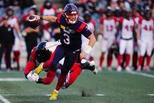 Montreal Alouettes quarterback Davis Alexander (3) is able to evade a tackle by Ottawa Redblacks defensive end Lorenzo Mauldin (94) during first half CFL pre-season football action in Ottawa on Friday, May 26, 2023. THE CANADIAN PRESS/Sean Kilpatrick
