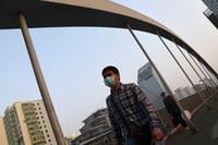 A man wearing a face mask walks on an overpass, following the coronavirus disease (COVID-19) outbreak, in Beijing, China April 8, 2022. REUTERS/Tingshu Wang