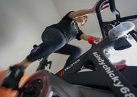 In this photo made on Sunday, Aug. 8, 2021, Cindy Cicchinelli uses her Peloton exercise machine in the workout room of her Pittsburgh townhouse.