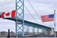 Canadian and American flags fly near the Ambassador Bridge at the Canada/USA border crossing in Windsor, Ont. on March 21, 2020. When the mayor of a village in southern Alberta stares across the border, he sees family and friends who just happen to call Montana home. The port of entry between Coutts, Alta., and Sweet Grass, Mont., is one of the busiest on the Canada-United States border, an important crossing on a trade route starting in Mexico. THE CANADIAN PRESS/Rob Gurdebeke
