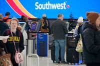 Travelers queue up at the check-in kiosks for Southwest Airlines in Denver International Airport Friday, Dec. 30, 2022, in Denver. (AP Photo/David Zalubowski)