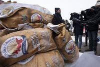 Prince Edward Island Premier Dennis King speaks with media as bags of potatoes sit on a table, Wednesday, Dec. 8, 2021 in Ottawa. THE CANADIAN PRESS/Adrian Wyld
