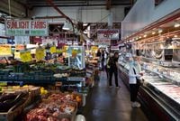 People shop for produce and seafood at the Granville Island Market in Vancouver, on Wednesday, July 20, 2022. Canada's inflation rate was up 8.1 per cent in June compared with a year ago, its largest yearly change since January 1983. THE CANADIAN PRESS/Darryl Dyck