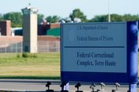A sign stands outside the Federal Correctional Institution, Terre Haute, as Daniel Lewis Lee, convicted in the killing of three members of an Arkansas family in 1996, is set to be put to death in the first federal execution in 17 years, in Terre Haute, Indiana, U.S. July 13, 2020.  REUTERS/Bryan Woolston