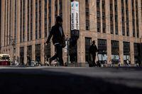 FILE PHOTO: People walk by a Twitter logo at the company headquarters in downtown San Francisco, California, U.S., April 25, 2022. REUTERS/Carlos Barria/File Photo