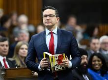 Conservative Leader Pierre Poilievre pauses as he is asked by Speaker of the House of Commons Anthony Rota, not shown, to refrain from using the book he was holding as a prop, as he rises during Question Period in the House of Commons on Parliament Hill in Ottawa on Thursday, March 30, 2023. THE CANADIAN PRESS/Justin Tang