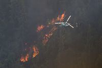 A B.C. Wildfire Service helicopter uses a PSD machine to drop ping-pong ball sized incendiary devices onto an area of the Keremeos Creek wildfire as part of a planned aerial ignition operation on August 16, 2022