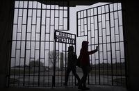 People take photos as they enter the Sachsenhausen Nazi death camp through the gate with the phrase 'Arbeit macht frei' (work sets you free), in Oranienburg, about 30 kilometres north of Berlin, Tuesday, Jan. 25, 2022.&nbsp;The Federal government is to use a bill enacting the budget to change the Criminal Code this year, building on existing laws outlawing the incitement of hatred. THE CANADIAN PRESS/AP-Markus Schreiber