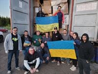 Members of UHelpUkraine, a non profit organization are seen holding flags signed by battalions of Ukrainian troops fighting in Ukraine. UHelpUkraine is trying to raise $7-million to fund various programs in Ukraine. Handout