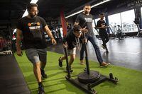 Pavi Toor (left) and boxing coach Kultar Gill ( right) cheer on Pravin Toor (centre) during a workout session with the non-profit training club Pavi started for teenagers in Abbotsford, B.C. called Young Guns.