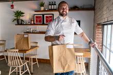 Matt Baker, chef and owner of Gravitas, poses for a portrait inside the restaurant, Tuesday, Feb. 14, 2023, in Washington. Gravitas has a subscription service offering a monthly meal for two. (AP Photo/Jacquelyn Martin)