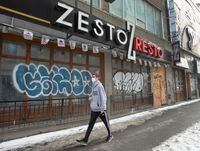A pedestrian walks past a row of closed storefronts as the COVID-19 pandemic continues to take its toll on businesses downtown, Monday, January 25, 2021 in Montreal.THE CANADIAN PRESS/Ryan Remiorz