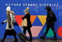 Shoppers wearing protective masks walk on Oxford Street, as rules on wearing face coverings in some settings in England are relaxed, amid the spread of the coronavirus disease (COVID-19) pandemic, in London, Britain January 27, 2022. REUTERS/Toby Melville