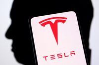 FILE PHOTO: Tesla logo and Elon Musk silhouette are seen in this illustration taken, December 19, 2022. REUTERS/Dado Ruvic/Illustration/File Photo