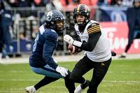 Hamilton Tiger-Cats quarterback Dane Evans (9) is defended by Toronto Argonauts defensive back Chris Edwards (6) during first half CFL Eastern Conference final action in Toronto, on Sunday, December 5, 2021. THE CANADIAN PRESS/Christopher Katsarov