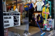 A clothing store announces the Argentine peso's informal exchange rate to U.S. dollars, Brazilian Reals and the Euro in Buenos Aires, Argentina, Friday, April 21, 2023. (AP Photo/Natacha Pisarenko)