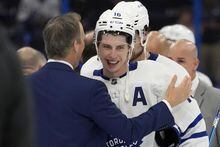 Toronto Maple Leafs right wing Mitchell Marner (16) talks to Tampa Bay Lightning head coach Jon Cooper after the Maple Leafs defeated the Lightning during overtime in Game 6 of an NHL hockey Stanley Cup first-round playoff series Saturday, April 29, 2023, in Tampa, Fla. (AP Photo/Chris O'Meara)