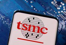 A smartphone with a displayed TSMC (Taiwan Semiconductor Manufacturing Company)  logo is placed on a computer motherboard in this illustration taken March 6.